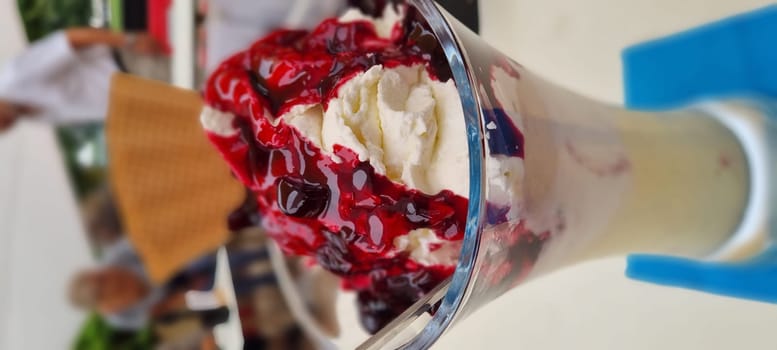 Close-up view of a tasty ice cream sundae with cherry topping in a glass cup