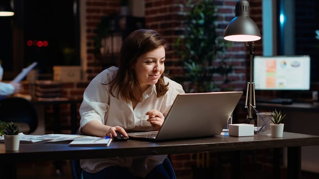 Woman in office celebrating finalizing deal with business partners, happy about incoming salary bonus. Employee in workplace dancing on chair after closing agreement with B2B clients, camera B