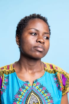 Portrait of charming person wearing traditional foreign attire, confident woman on camera. African American girl that radiates elegance and is a natural beauty, serious expression.