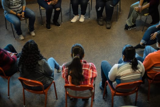 Overhead view of a diverse group of individuals seated in a circle for a group discussion, highlighting the concept of teamwork and collaboration