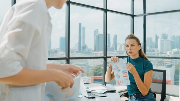 Professional female investor listening businessman present start up project statistic. Back view of businessman shows graph while manager using laptop analysis data at cityscape view. Tracery