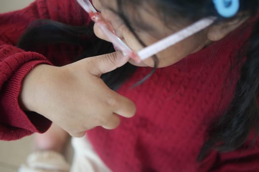 child girl biting her nails at home