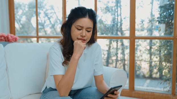 Young woman using smartphone browsing for online shopping E commerce by online payment gateway at vivancy home. Modern and convenience online purchasing make secure and convenient purchases.