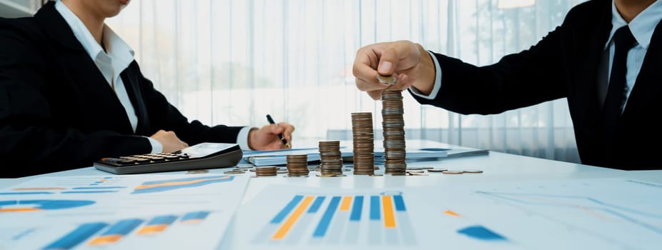 Growth coin stack symbolizing business investment and economic growth. Business people doing financial planning to achieve financial goal and contribute maximum profit gain . Shrewd