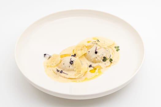 Cheese ravioli with sauces on a white porcelain plate