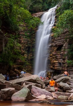 A peaceful waterfall flows down cliffs, captivating onlookers with its beauty.