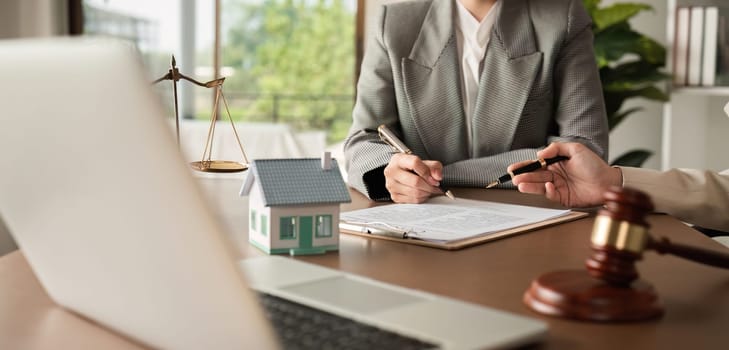 Lawyer and businesswoman signing a business contract regarding real estate law and property protection law Signing an insurance or financial contract.