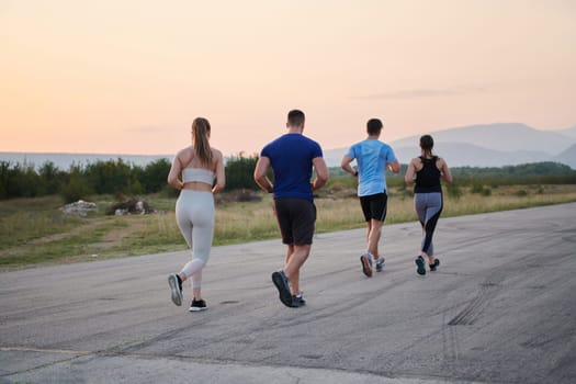 A group of friends maintains a healthy lifestyle by running outdoors on a sunny day, bonding over fitness and enjoying the energizing effects of exercise and nature.