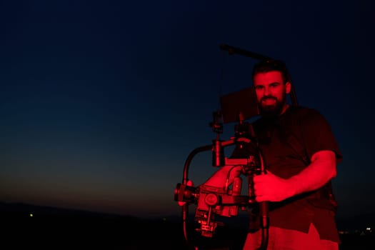 A skilled videographer captures the intensity of athletes running, illuminated by vibrant red lights, encapsulating the energy and determination of their nighttime training session.