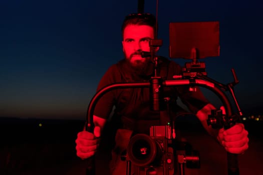 A skilled videographer captures the intensity of athletes running, illuminated by vibrant red lights, encapsulating the energy and determination of their nighttime training session.