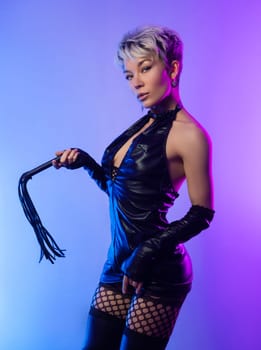 sexy girl in erotic bdsm image mistress in latex dress posing in front of copy paste neon background