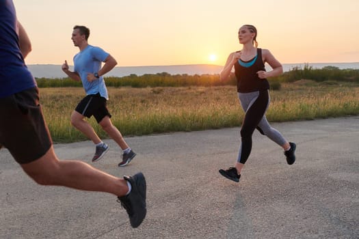 A diverse group of runners finds motivation and inspiration in each other as they train together for an upcoming competition, set against a breathtaking sunset backdrop.