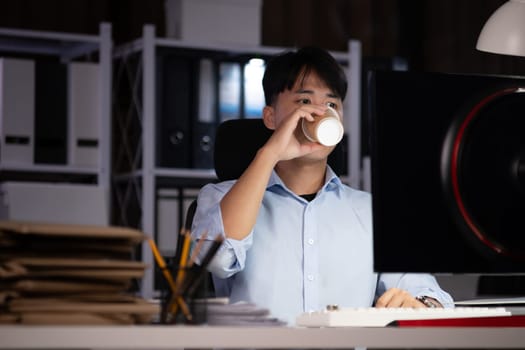 Businessman working hard overtime at night at the office. He felt tired and stressed from work.