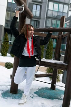 A woman in a winter outfit walks down the street and has fun.