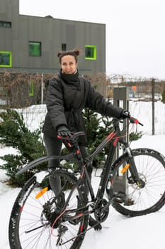 A pretty brunette woman dressed warmly and went out for a bike ride in winter.