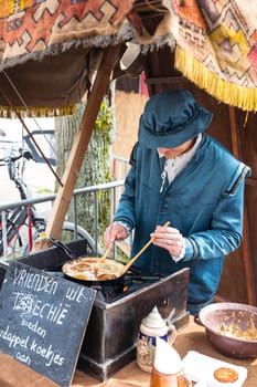 Brielle,Holland,1-04-2024:a man in traditional costume is backing pancackes during the celebration of the the first town to be liberated from the Spanish in Den Briel in the Netherlands