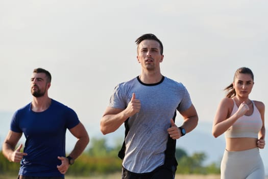 A group of friends maintains a healthy lifestyle by running outdoors on a sunny day, bonding over fitness and enjoying the energizing effects of exercise and nature.