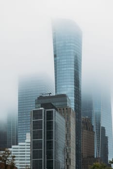 Skyscrapers loom through the fog, creating a ghostly metropolitan scene.