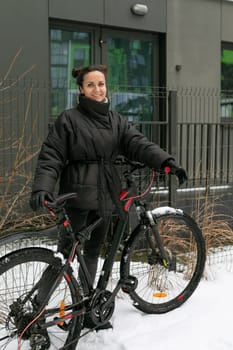 European young woman riding a bicycle in the cold.