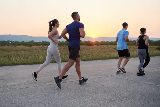 A diverse group of runners finds motivation and inspiration in each other as they train together for an upcoming competition, set against a breathtaking sunset backdrop.