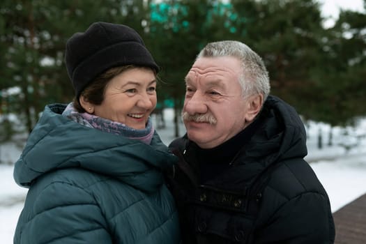 European mature family having fun walking through the winter forest.