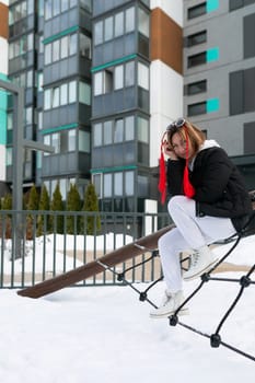 Young carefree woman having fun on the playground in winter.