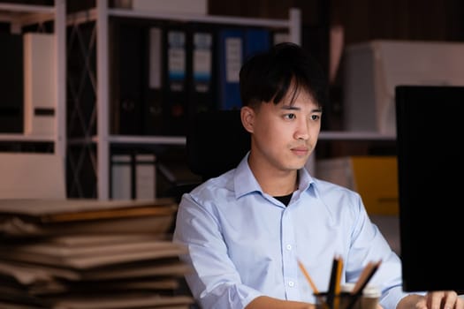 Businessman working hard overtime at night at the office. He felt tired and stressed from work.