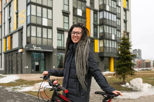 Photo on the street, a young woman stopped during a bike ride to rest.