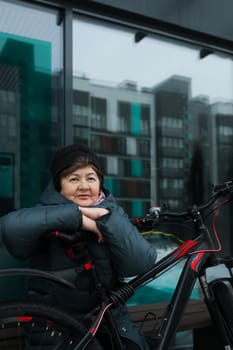 Mature European woman goes for a walk with a bicycle in winter.