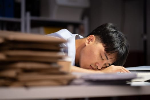 Businessman working hard overtime at night at the office. He felt tired and stressed from work.