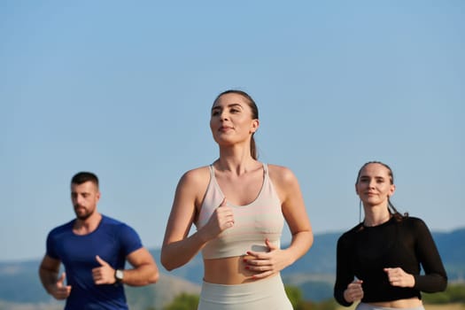 A group of friends maintains a healthy lifestyle by running outdoors on a sunny day, bonding over fitness and enjoying the energizing effects of exercise and nature.