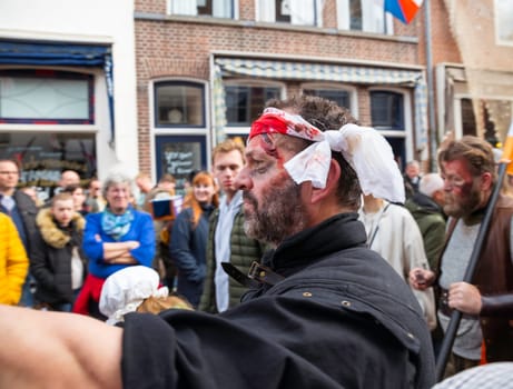 Brielle,Holland,1-04-2024:man plays wounded man in traditional traditional costumes celebration of the the first town to be liberated from the Spanish in Den Briel in the Netherlands in 1572