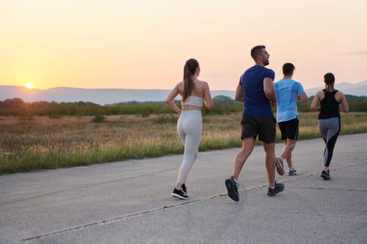 A diverse group of runners finds motivation and inspiration in each other as they train together for an upcoming competition, set against a breathtaking sunset backdrop.