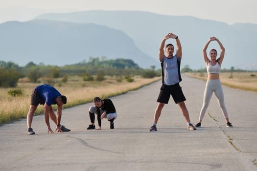 A determined group of athletes engage in a collective stretching session before their run, fostering teamwork and preparation in pursuit of their fitness goals.