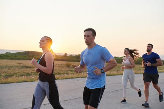 A diverse group of runners finds motivation and inspiration in each other as they train together for an upcoming competition, set against a breathtaking sunset backdrop.