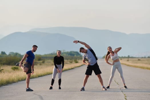 A determined group of athletes engage in a collective stretching session before their run, fostering teamwork and preparation in pursuit of their fitness goals.