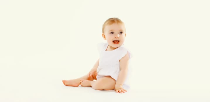 Portrait of happy cute baby crawling on the floor on white studio background