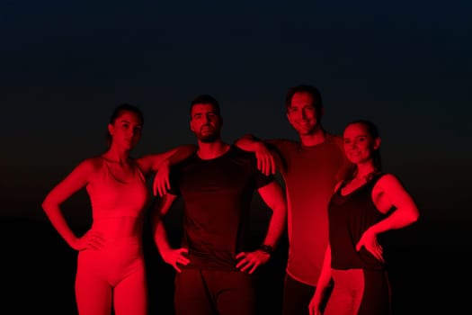 In the late-night hours, a diverse group of exhausted athletes find solace under a red glow, reflecting on their day-long marathon journey and celebrating camaraderie amidst fatigue.