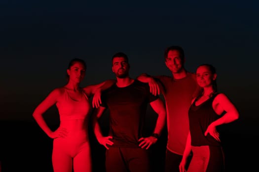 In the late-night hours, a diverse group of exhausted athletes find solace under a red glow, reflecting on their day-long marathon journey and celebrating camaraderie amidst fatigue.