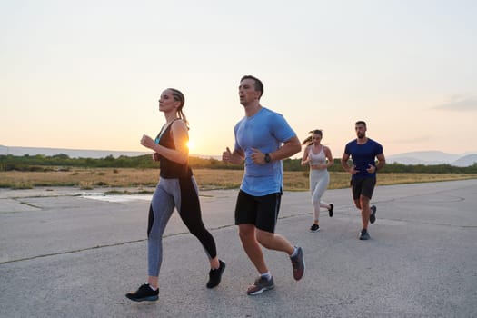 A diverse group of runners finds motivation and inspiration in each other as they train together for an upcoming competition, set against a breathtaking sunset backdrop.