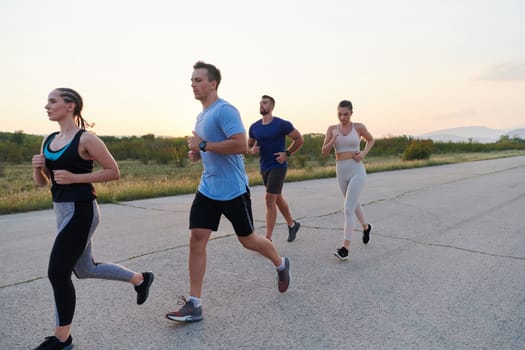 A diverse group of runners finds motivation and inspiration in each other as they train together for an upcoming competition, set against a breathtaking sunset backdrop.