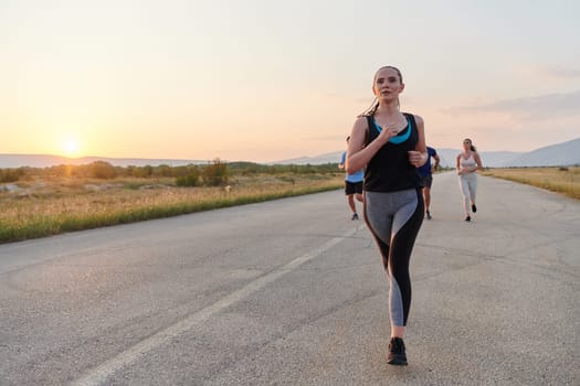 A diverse group of runners finds motivation and inspiration in each other as they train together for an upcoming competition, set against a breathtaking sunset backdrop.