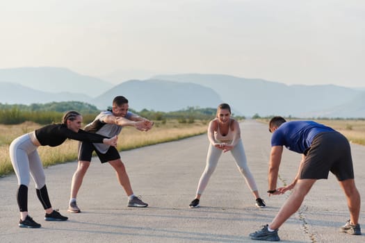 A determined group of athletes engage in a collective stretching session before their run, fostering teamwork and preparation in pursuit of their fitness goals.