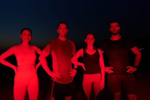 In the late-night hours, a diverse group of exhausted athletes find solace under a red glow, reflecting on their day-long marathon journey and celebrating camaraderie amidst fatigue.