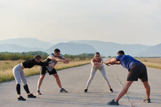 A determined group of athletes engage in a collective stretching session before their run, fostering teamwork and preparation in pursuit of their fitness goals.