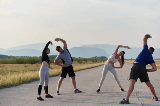 A determined group of athletes engage in a collective stretching session before their run, fostering teamwork and preparation in pursuit of their fitness goals.