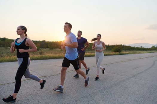 A diverse group of runners finds motivation and inspiration in each other as they train together for an upcoming competition, set against a breathtaking sunset backdrop.