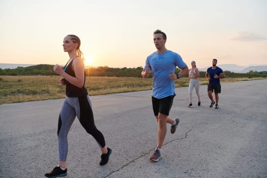 A diverse group of runners finds motivation and inspiration in each other as they train together for an upcoming competition, set against a breathtaking sunset backdrop.