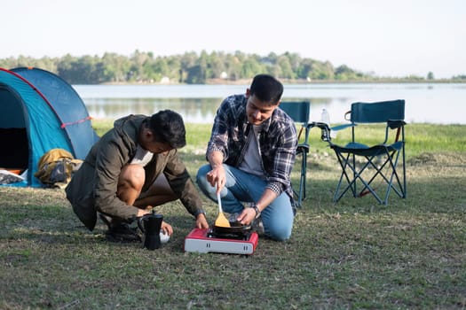 Asian homosexual couple spending their free time on holiday Camp to relax, cook and enjoy the outdoors together..