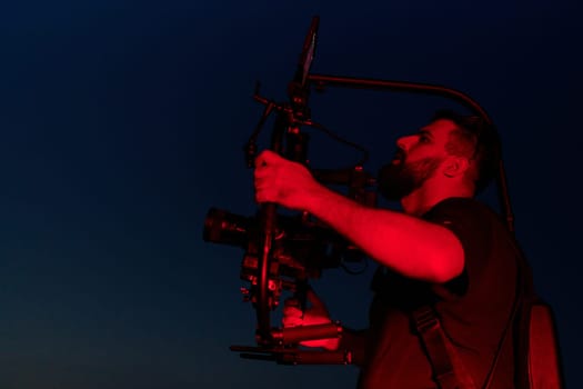 A skilled videographer captures the intensity of athletes running, illuminated by vibrant red lights, encapsulating the energy and determination of their nighttime training session.